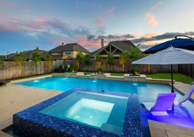 houston pool builder - a pool at night with loungers